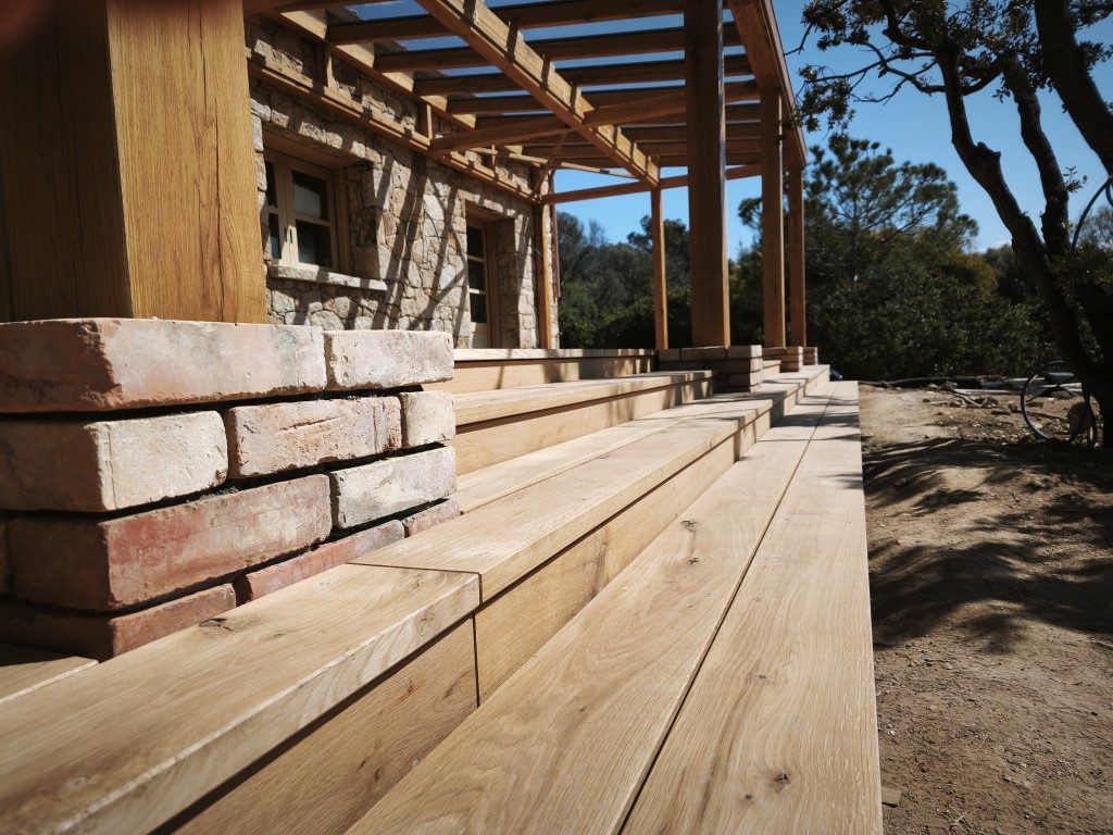 Pfosten auf Ziegelsockel neben Holzstufen