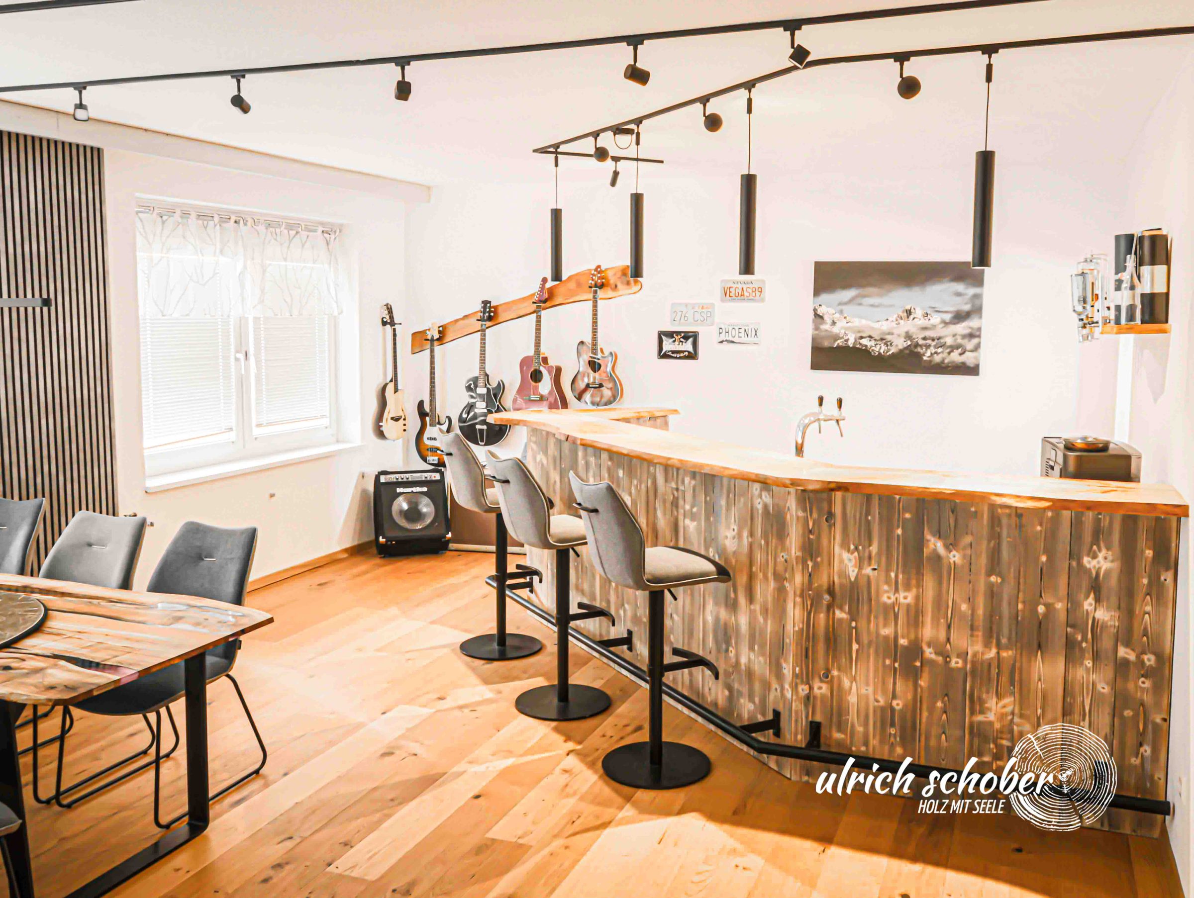 Hausbar mit Baumkanten-Theke, Barhockern und Gitarren an der Wand
