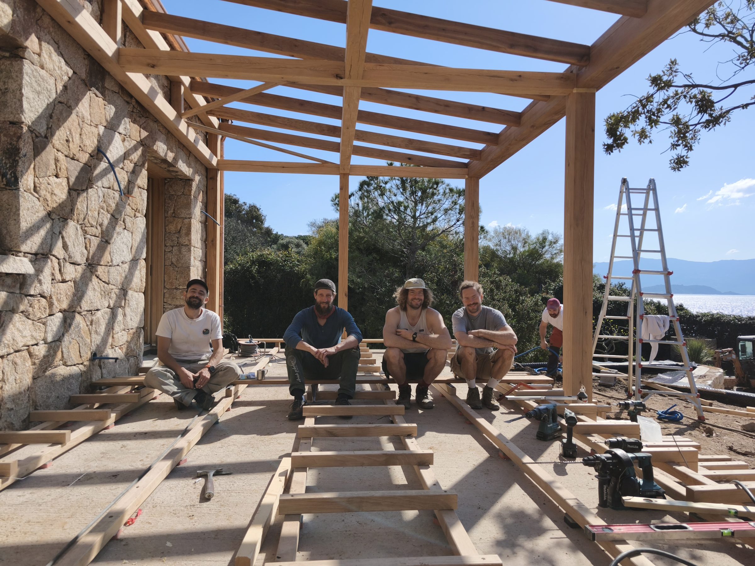 Das Montageteam sitzt unter der fertigen Pergola
