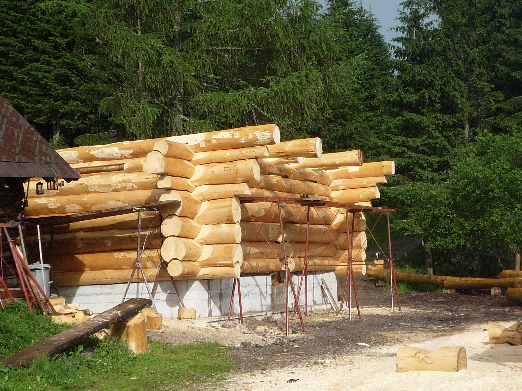 Rohbau eines Blockhauses aus Rundholz auf Betonsockel