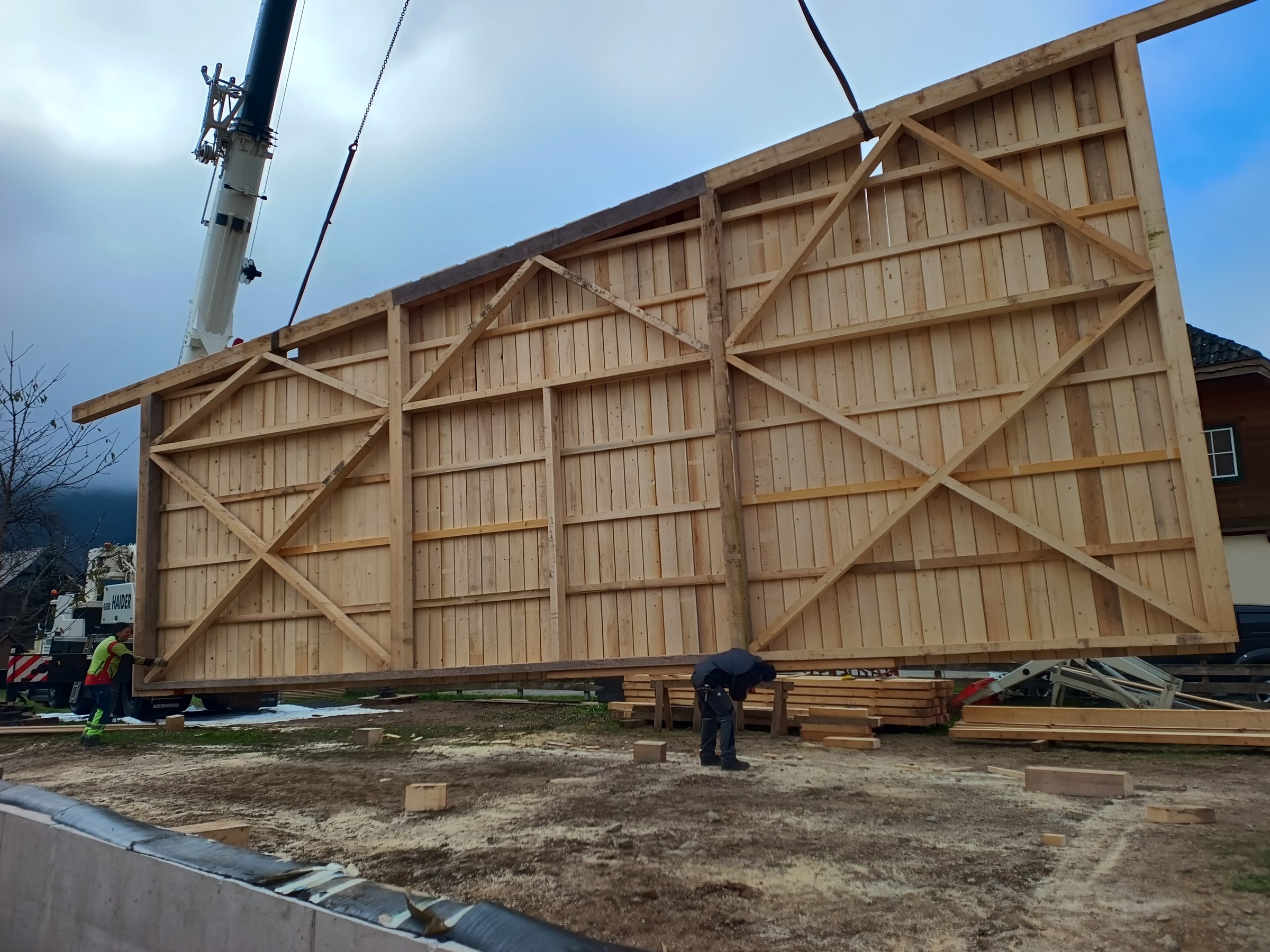 Großes Wandelement aus Holz hängt am Kran