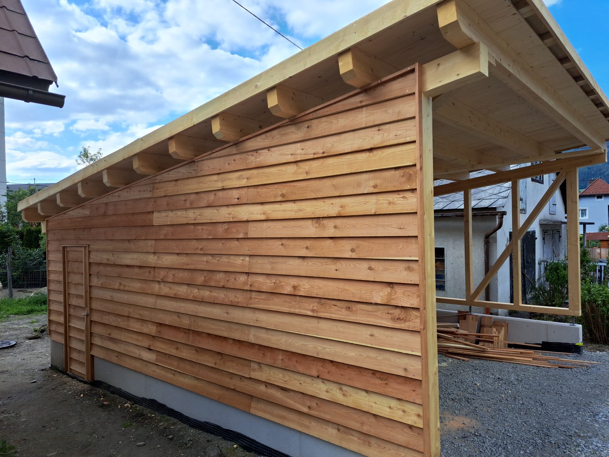 Seitenwand des Carports mit Stülpschalung