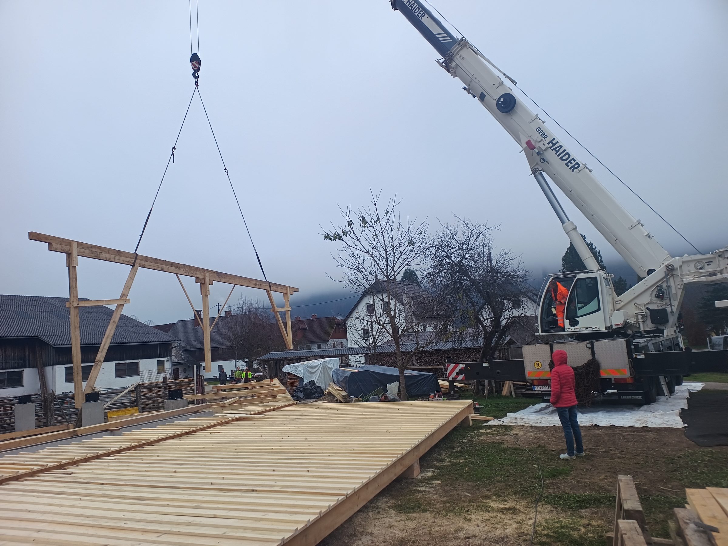 Ein Holzbinder hängt am Autokran