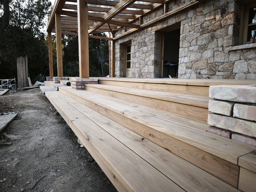 Treppenanlage aus Massivholz mit Ziegelpfeiler